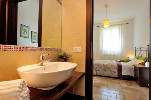 a bathroom with a sink and a bed at Agriturismo Il Vecchio Mandorlo in Perugia