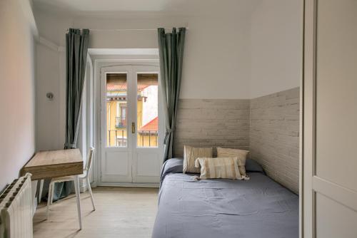 a bedroom with a blue bed and a brick wall at Cómodo apartamento con 6 habitaciones en el centro in Madrid