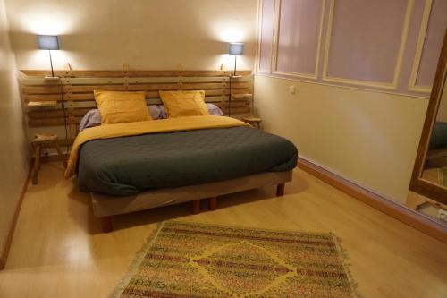 a bedroom with a bed with two pillows and a rug at Chambre d'hôtes Kerioret Izella in Kerlaz