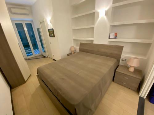 a bedroom with a large bed and shelves at Appartamento LA ROSA in Riva Trigoso