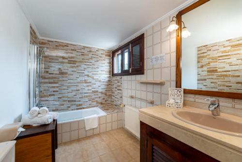 a bathroom with a bath tub and a sink at Finca Hotel Rural Predio Son Serra in Can Picafort