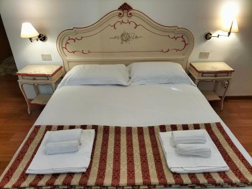 um quarto com uma cama grande e duas mesas em RIALTO EXPERIENCE em Veneza