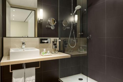 a bathroom with a sink and a shower at NH Amsterdam Zuid in Amsterdam