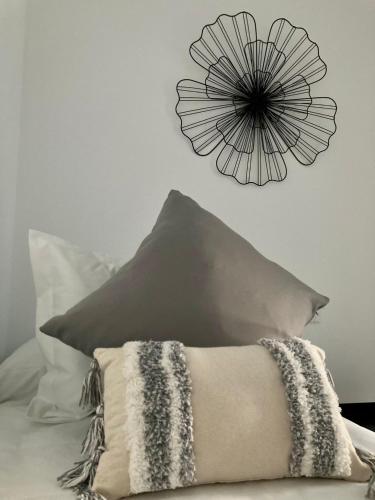 a flower clock on the wall above a pillow at PIEDRA DE LUNA in Merida