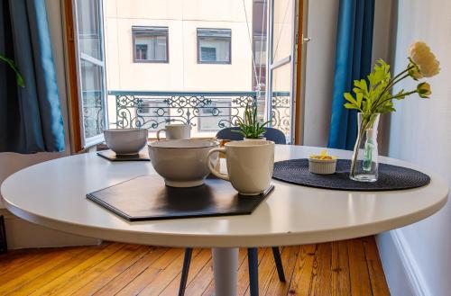 a white table with cups on it in front of a window at Brotteaux in Lyon