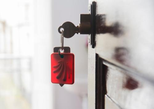 una puerta roja con un símbolo de fuego. en Pensión Santa Cristina, en Santiago de Compostela
