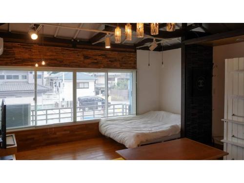 a bedroom with a bed and a large window at SHONAN garden - Vacation STAY 15108v in Kamakura