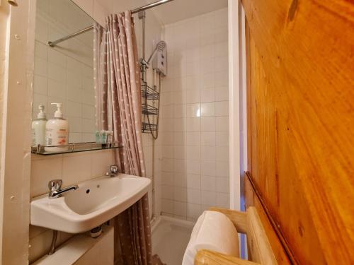 a bathroom with a sink and a bath tub at 17th-Century One Bed Studio with Parking & Garden! in Elkesley