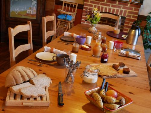 een houten tafel met brood en ander voedsel erop bij Kerioret Izella in Kerlaz