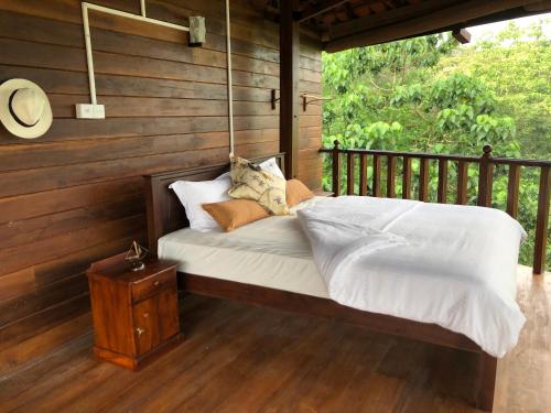 uma cama num quarto num alpendre em Wanakaset Forest Glamping em Kitulgala