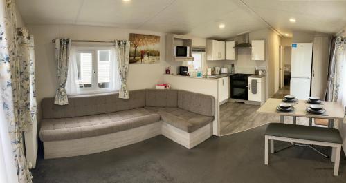 a living room with a couch and a kitchen at Seaview Holiday Rentals in Kent