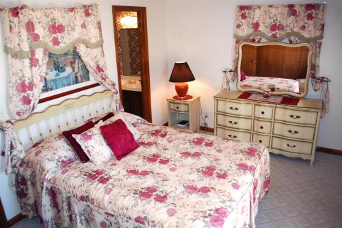 a bedroom with a bed with a dresser and a mirror at 10328 - 28 Opalo Place in Hot Springs Village