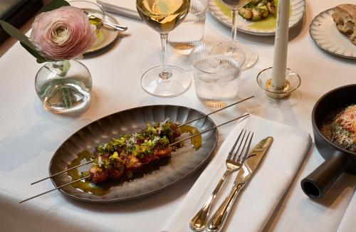 a plate of food on a table with wine glasses at Villa Dagmar in Stockholm