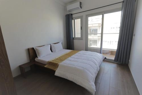 a bed in a room with a large window at Les Residences de la Diaspora in Dakar