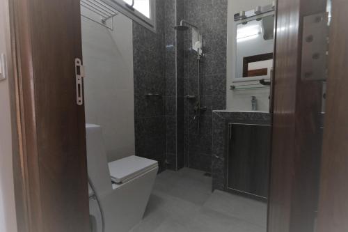 a bathroom with a toilet and a shower and a sink at Les Residences de la Diaspora in Dakar
