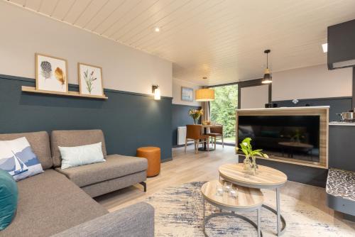 a living room with a couch and a tv at Center Parcs Vossemeren in Lommel