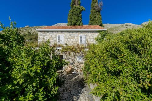 una vieja casa de piedra en medio de árboles en Villa Soline, en Mlini