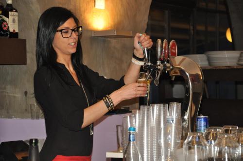 Kobieta nalewa wino do szklanki. w obiekcie Hotel Beata Giovannina w mieście Verbania