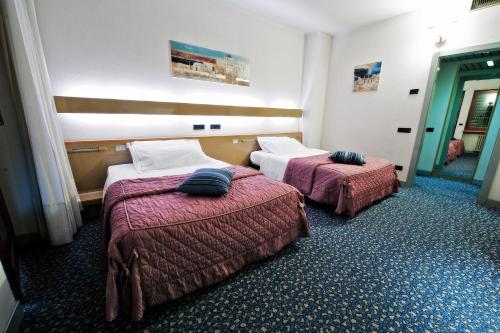 ein Hotelzimmer mit 2 Betten in einem Zimmer in der Unterkunft Hotel Michelangelo in Biella