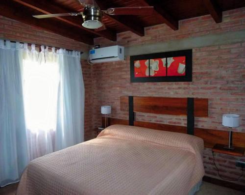 a bedroom with a bed and a brick wall at Altos de San Blas in San Javier