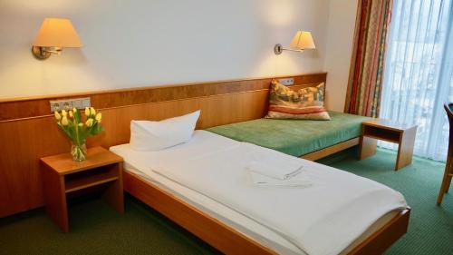 a hotel room with a bed and a chair at Landhotel Günzburg in Kupferzell