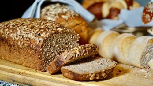 Landhotel Günzburg في Kupferzell: مجموعة من أنواع الخبز المختلفة على لوح التقطيع