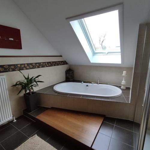 a bathroom with a large bath tub with a window at Ferienwohnung Adelhardt in Eckersdorf