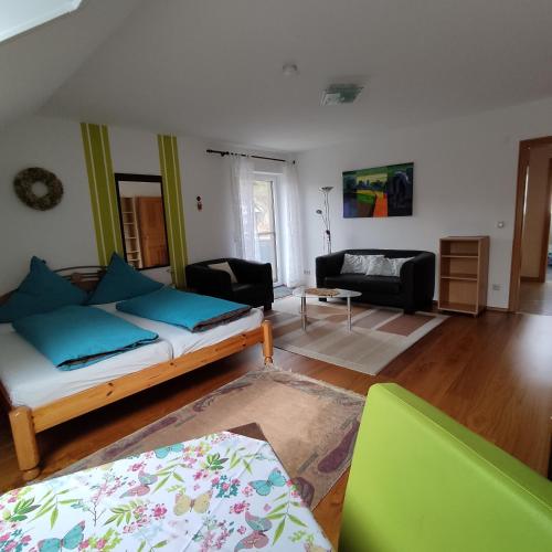 a living room with a bed and a couch at Ferienwohnung Adelhardt in Eckersdorf