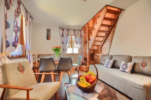 a living room with a couch and a table with a bowl of fruit at Zbójnicka Chata Wisła in Wisła