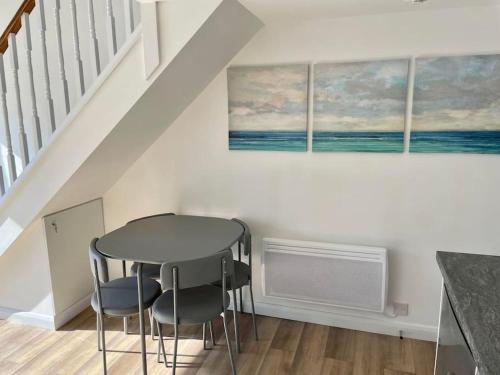 - une salle à manger avec une table et deux chaises dans l'établissement Whispering Waves in Porthtowan @ Cornwall Coastal Holidays, à Porthtowan
