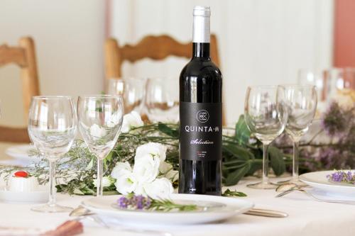 uma garrafa de vinho sentada numa mesa com copos em Quinta M - Portugal em Casével