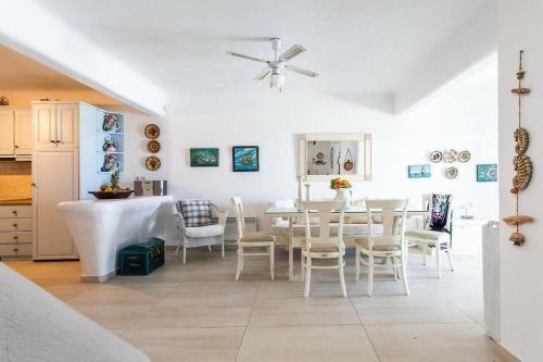 una cucina e una sala da pranzo con tavolo e sedie di Mykonos Coastal Retreat - Giovanna's Beachfront Escape with Jacuzzi a Mykonos Città