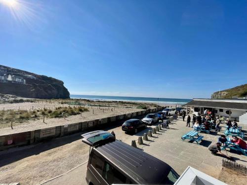a group of cars parked at a station next to the beach at Whispering Waves in Porthtowan @ Cornwall Coastal Holidays in Porthtowan