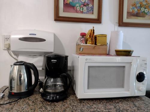 un bancone cucina con forno a microonde e macchinetta del caffè di Casa en Tandil a Tandil