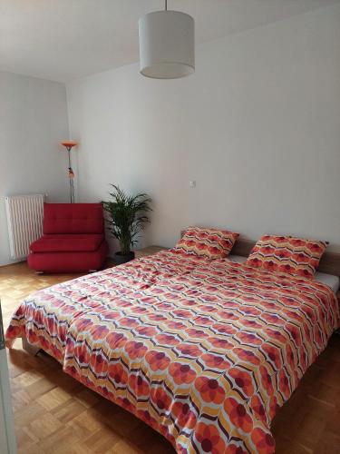 a bedroom with a bed and a red couch at Apartma Rožmarin Bohinj in Bohinj