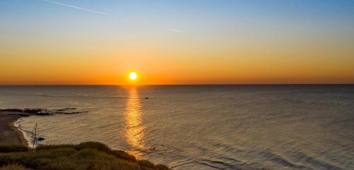 a sunset over the ocean with the sun setting at Hôtel Bellevue Cap d'Agde in Cap d'Agde