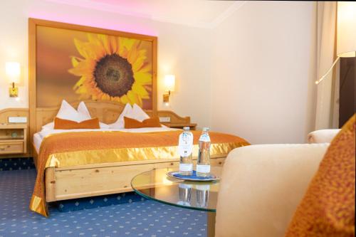 a hotel room with a bed and a sunflower mural at EUROPÄISCHER HOF Bad Gastein in Bad Gastein