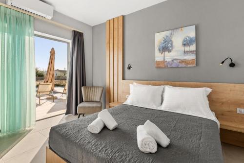 a bedroom with a bed with two white towels on it at Sarah Luxury Rooms in Syvota