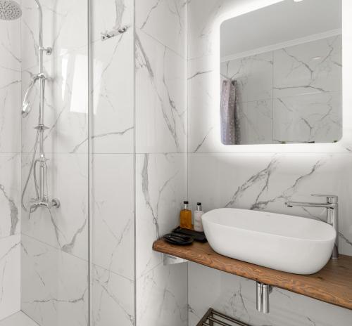 a white bathroom with a sink and a mirror at Sarah Luxury Rooms in Syvota