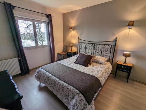 a bedroom with a large bed and a window at La Maison de Boyeux in Châtillon
