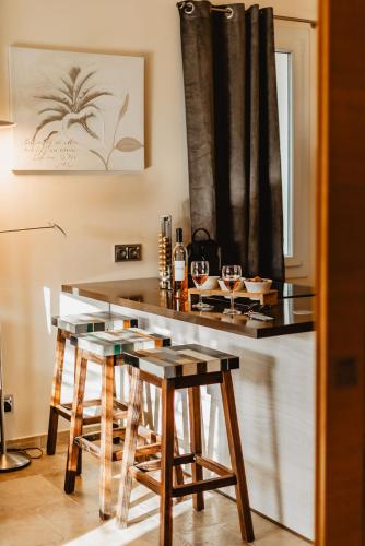 a kitchen with a bar with stools and wine glasses at Les Maisons Du Sud in Saint-Tropez