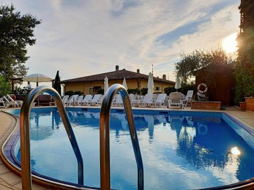una piscina con due ringhiere metalliche intorno ad essa di Viole Country Hotel ad Assisi