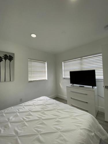 um quarto branco com uma cama e uma televisão de ecrã plano em Modern Home, Excellent Location Miami em Miami