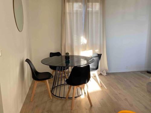 une salle à manger avec une table et des chaises noires dans l'établissement Les Clés de Rodez, à Rodez