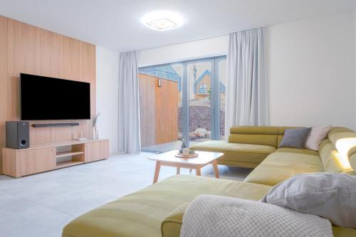 a living room with a couch and a television at TATRYSTAY Brezy Luxury Apartment in Stará Lesná