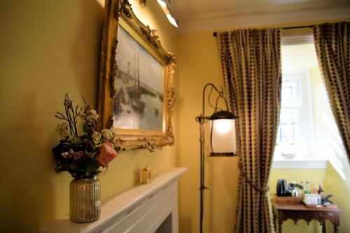 a living room with a vase of flowers on a fireplace at Barcaldine Castle in Oban