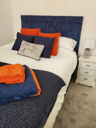 un grande letto con cuscini arancioni e blu sopra di Ipswich Town Centre - Apartment 6 a Ipswich