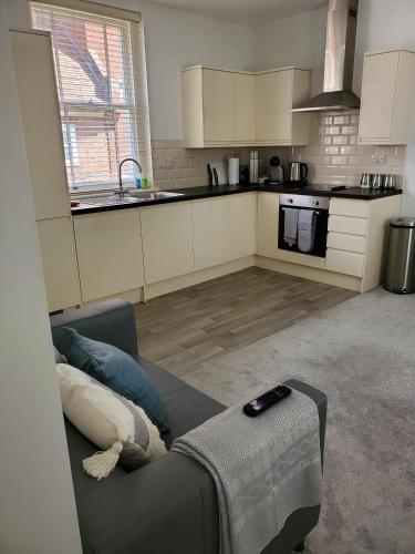 a living room with a couch and a kitchen at Ipswich Town Centre - Apartment 6 in Ipswich