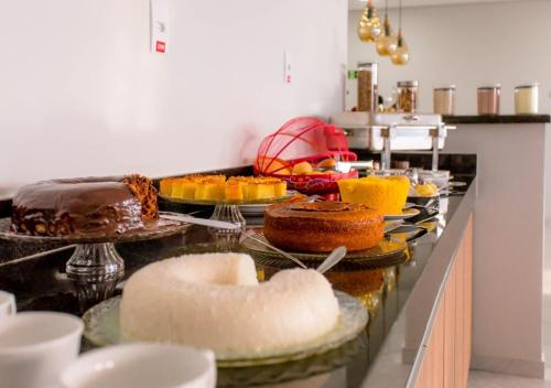 a buffet with cakes and other desserts on a counter at KK Palace Hotel in Eunápolis