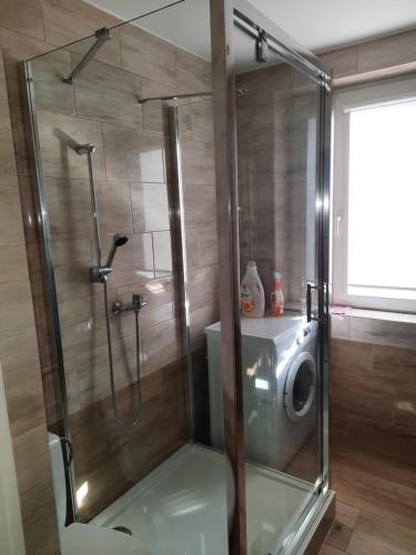 um chuveiro com uma porta de vidro na casa de banho em Villa Park Leśna em Brzeźno